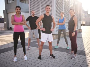 Happy young multiracial athletes standing on city square